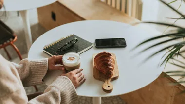 frothed milk in coffee with pastries on table