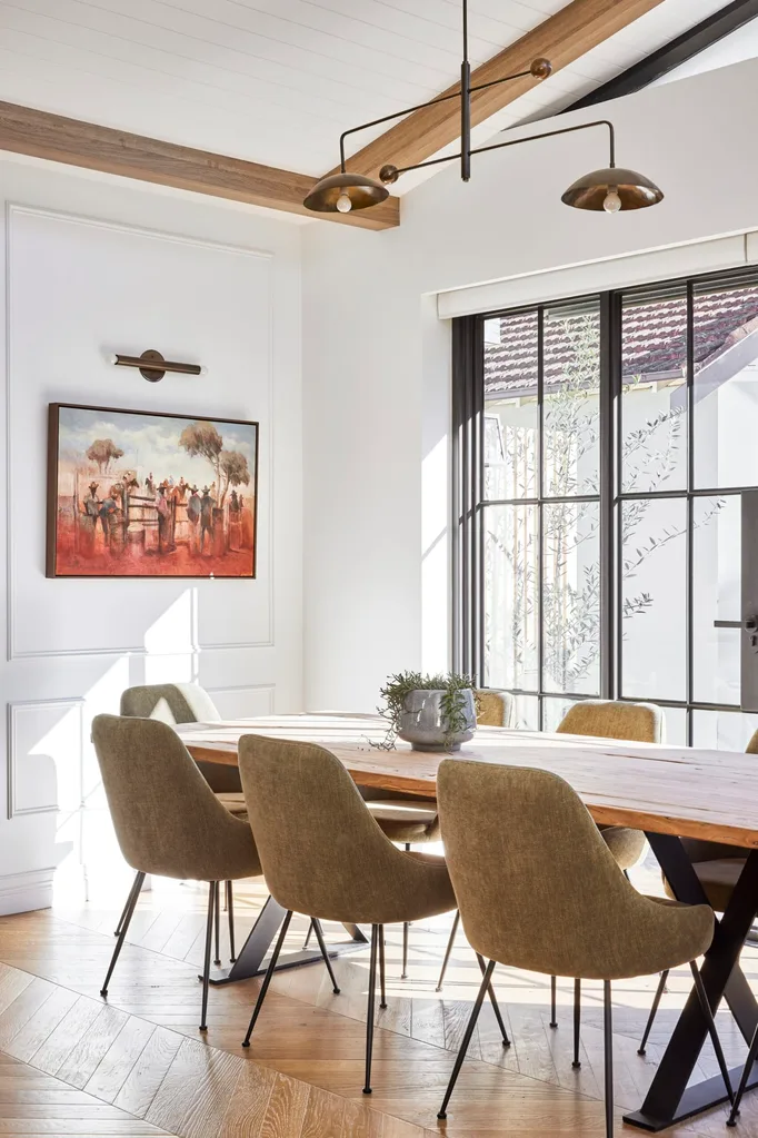 Californian bungalow renovation neutral dining room with timber table, fabric chairs, wainscoting and steel doors
