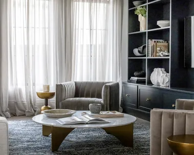 Coco Republic Interior Design Masterclass living room armchair with statement modern chandelier custom bookshelves and sheer curtains