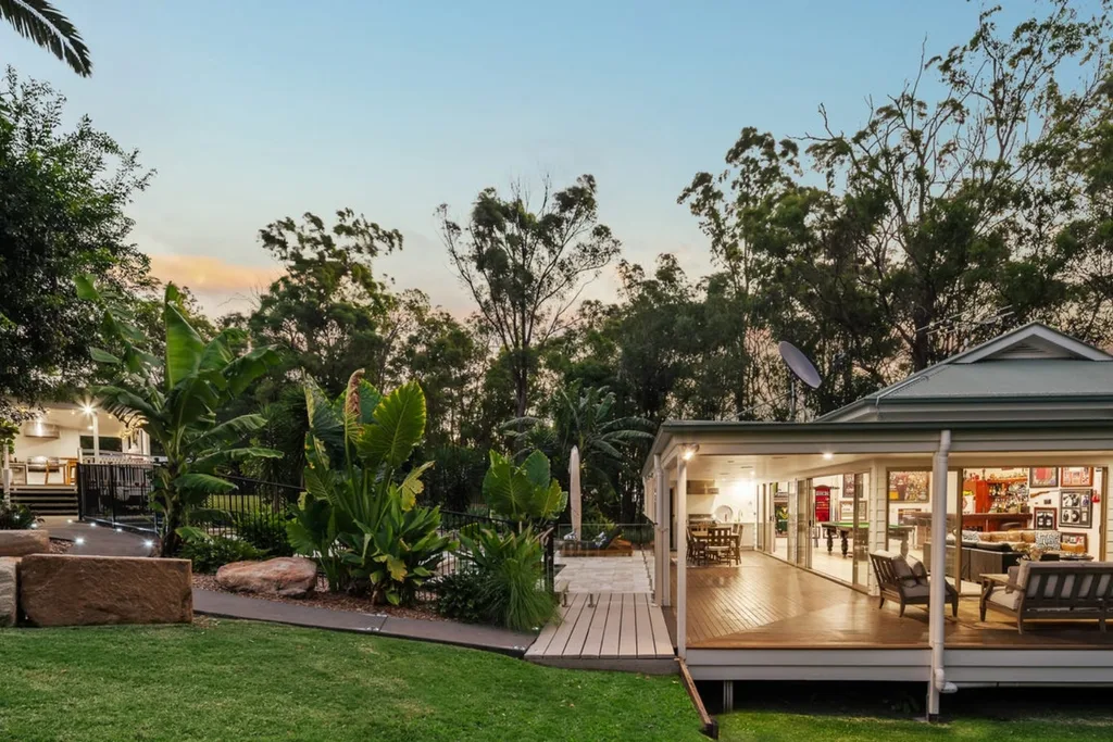Corey Parker Daisy Hill home backyard with leafy pool and outdoor sitting area and Broncos memorabilia