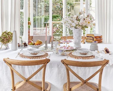 Mothers Day Decorating Table With Flowers Candles Cake and Dinnerware