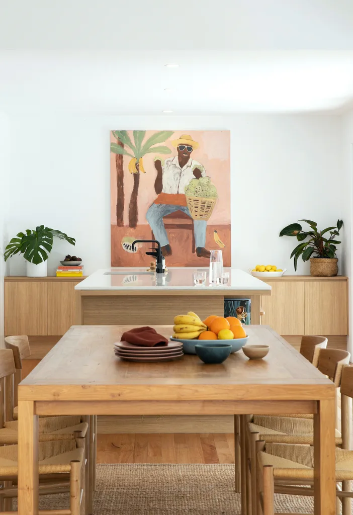 A clean kitchen and dining area with plates on the table.